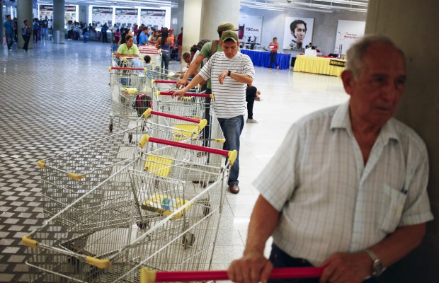 Customers line up to get in for shopping at a state-run Bicentenario supermarket in Caracas May 2, 2014.  President Nicolas Maduro is introducing a controversial shopping card intended to combat Venezuela's food shortages but decried by critics as a Cuban-style policy illustrating the failure of his socialist policies. Maduro, the 51-year-old successor to Hugo Chavez, trumpets the new "Secure Food Supply" card, which will set limits on purchases, as a way to stop unscrupulous shoppers stocking up on subsidized groceries and reselling them. REUTERS/Jorge Silva (VENEZUELA - Tags: POLITICS BUSINESS SOCIETY TPX IMAGES OF THE DAY) - RTR3NL83